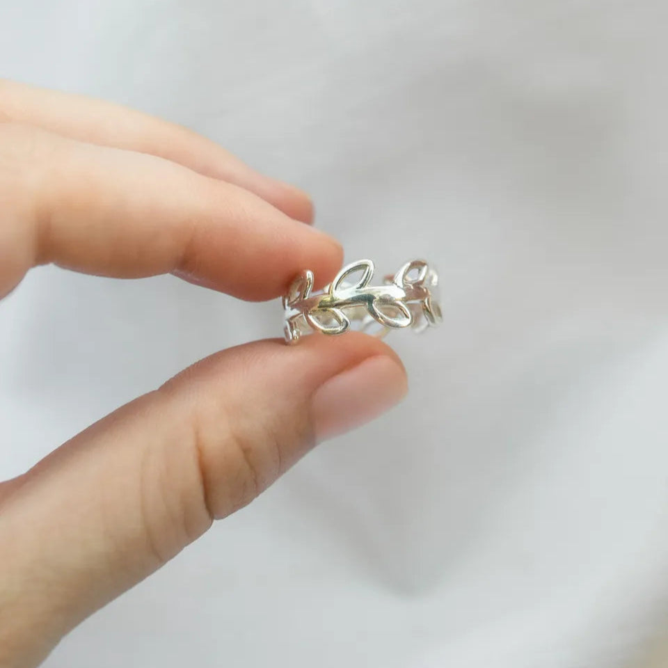 anillo plata olivo entre dedos
