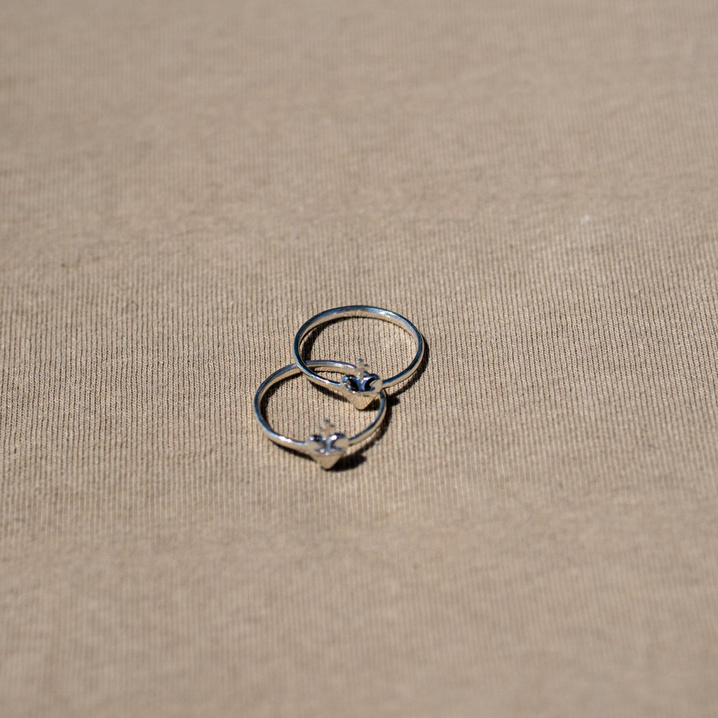 anillos de plata corazon sagrado sobre fondo textura