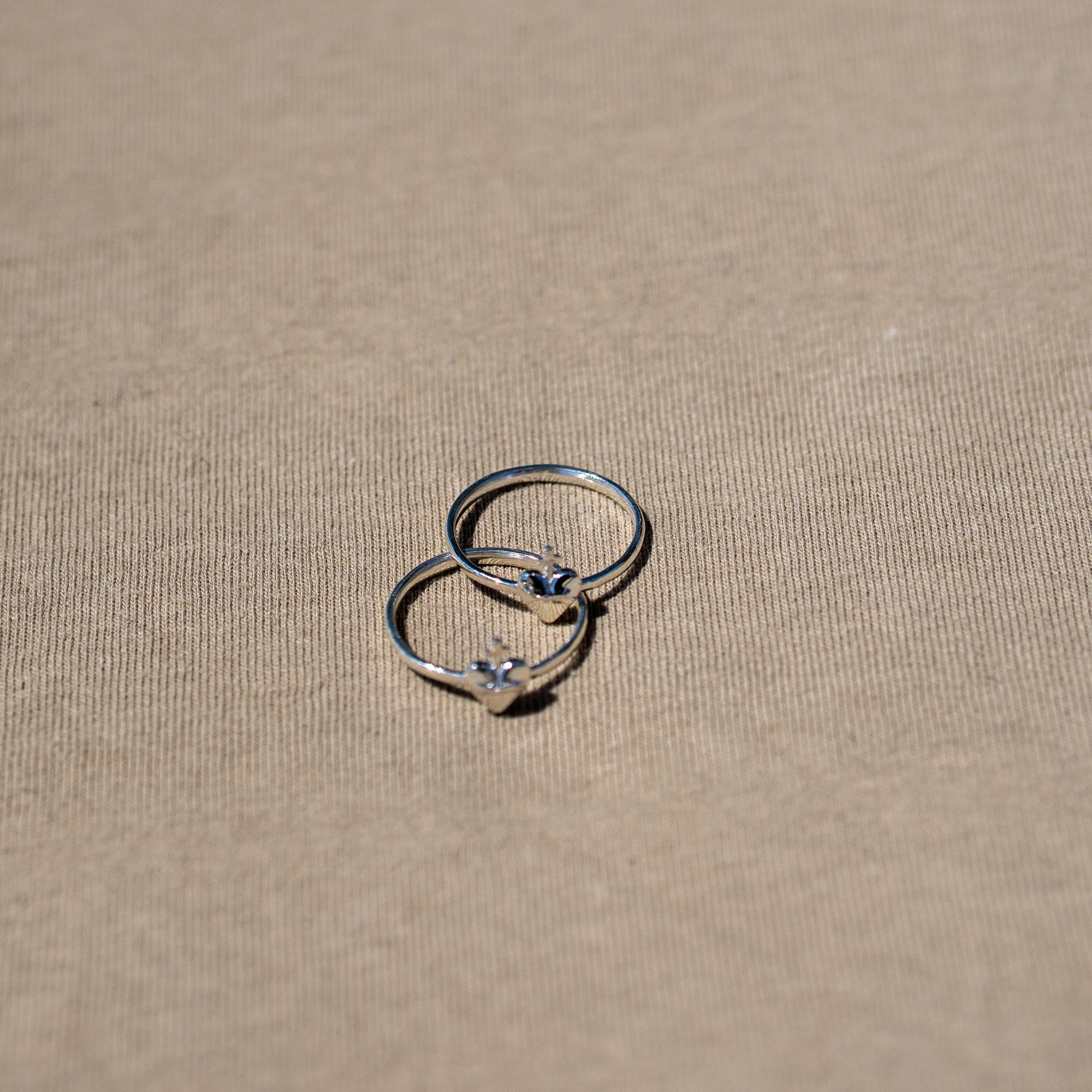 anillos de plata corazon sagrado sobre fondo textura
